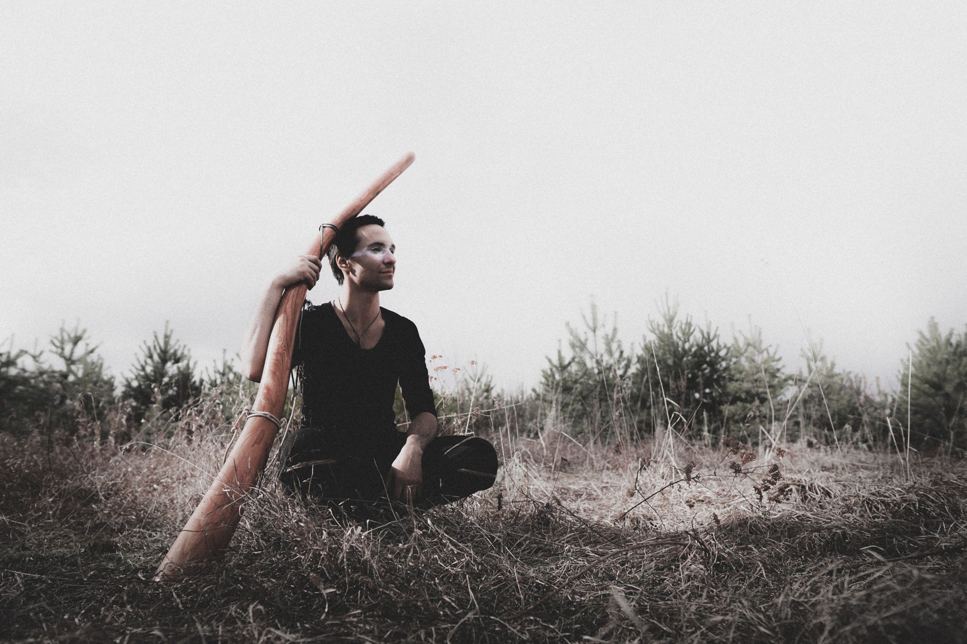 Persona tocando el didgeridoo soplando en el extremo del tubo