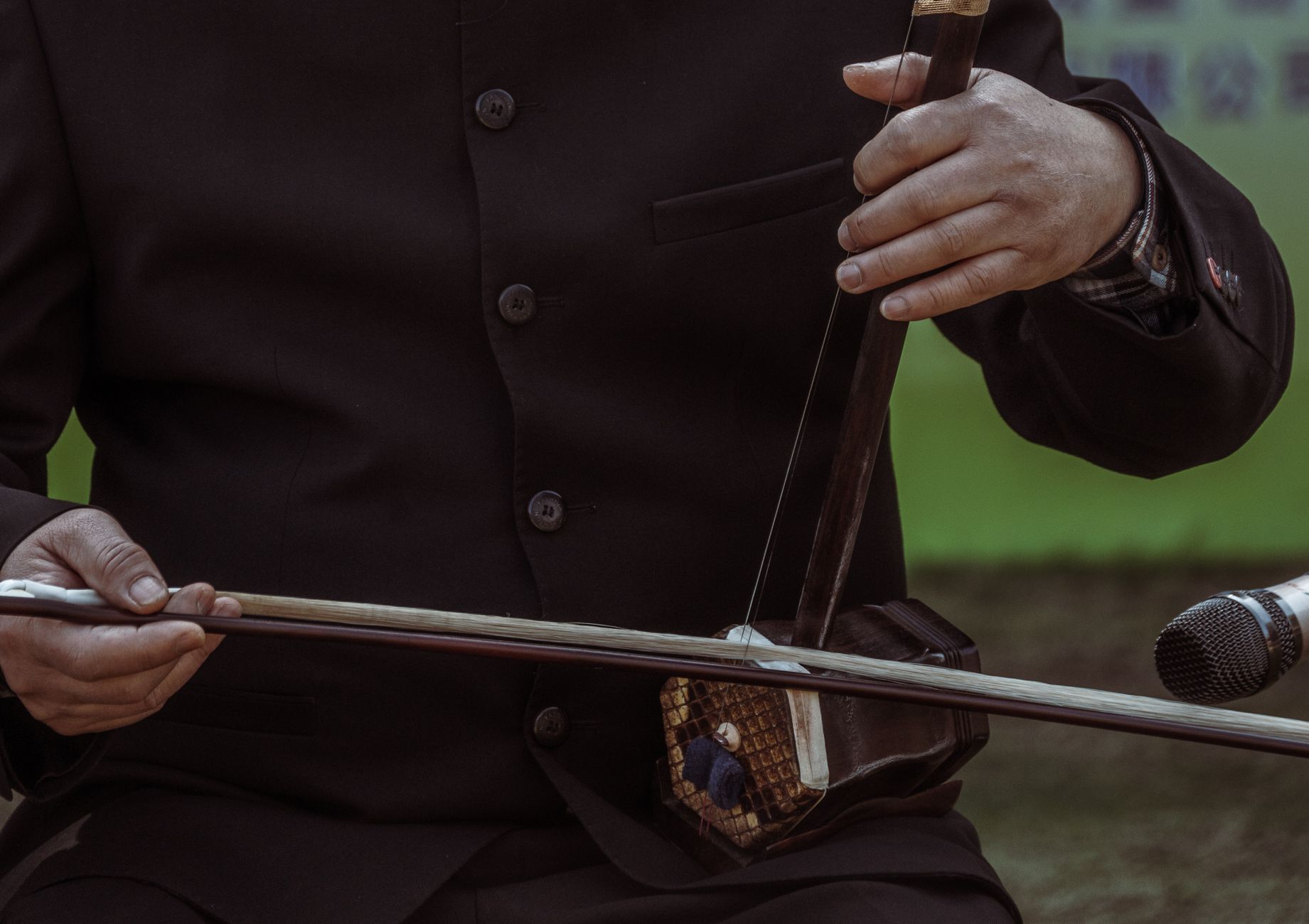 Close-up of a horsehair bow playing the two strings of an erhu