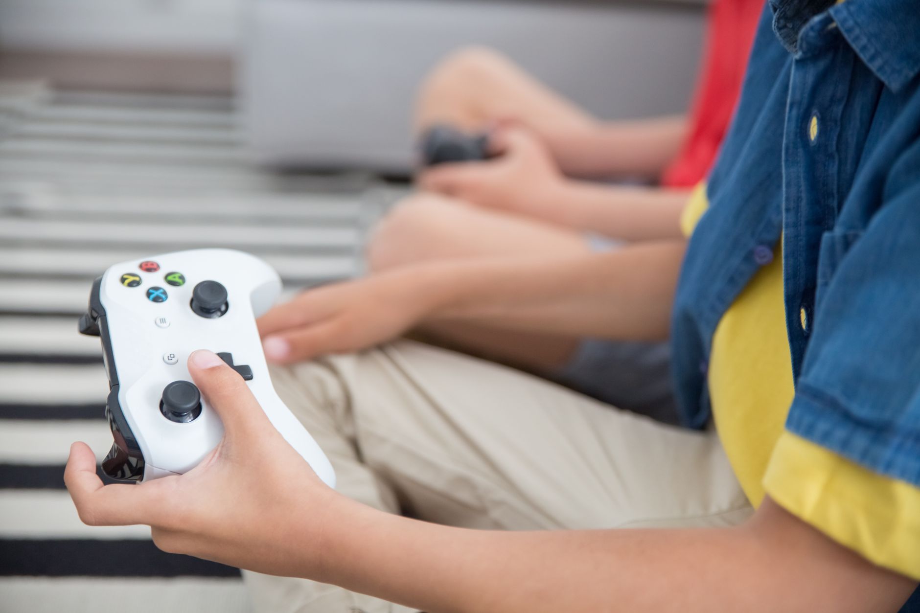 Niño jugando con un mando de videojuego, afición gamer relacionada con Pac-Man