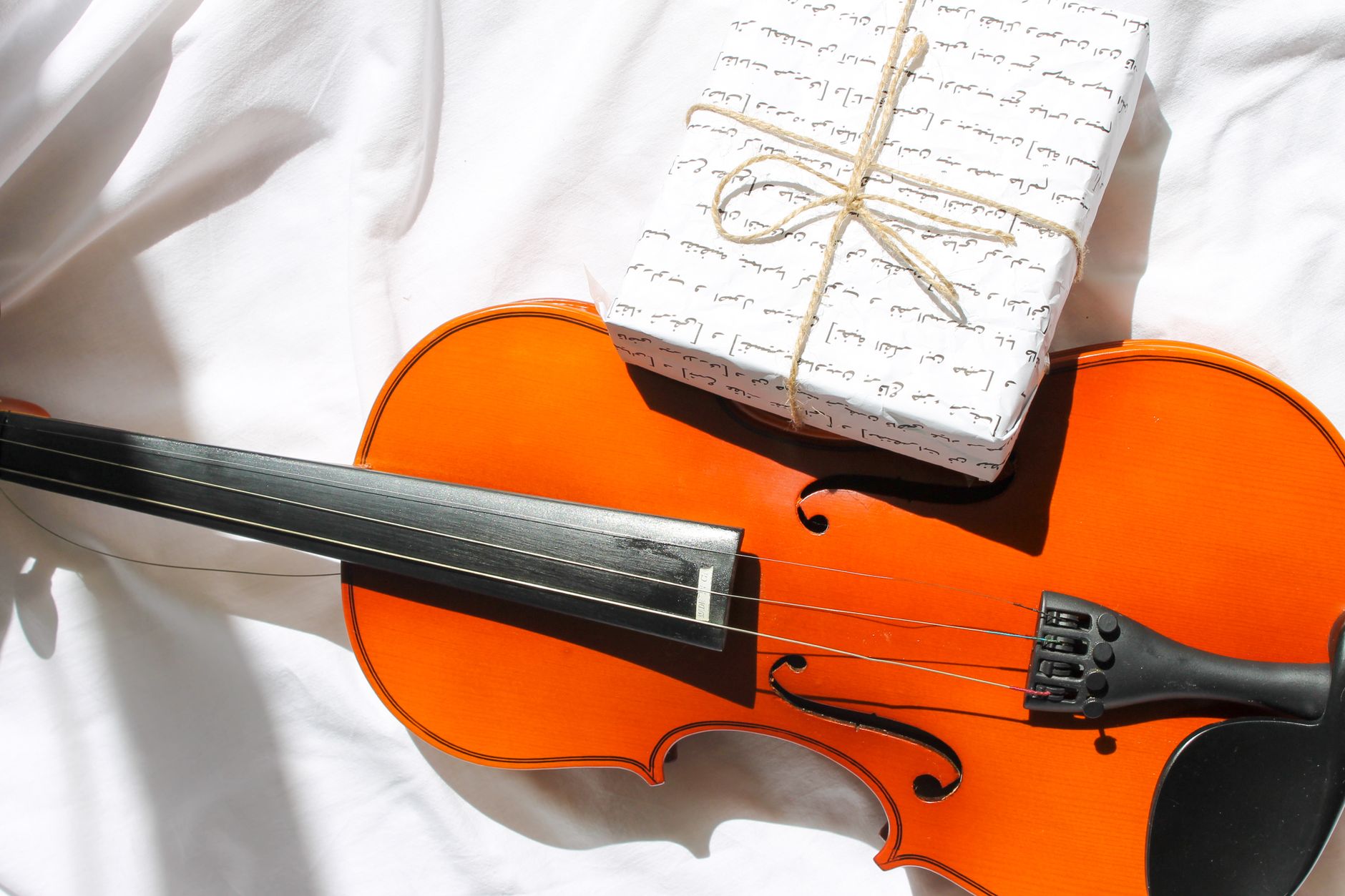 Caja de regalo envuelta junto a un instrumento musical, idea de regalo original